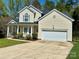 Charming home featuring a well-manicured lawn, cozy front porch, and an attached two-car garage at 10550 Worsley Ln, Charlotte, NC 28269