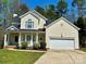 Charming home featuring a well-manicured lawn, cozy front porch, and an attached two-car garage at 10550 Worsley Ln, Charlotte, NC 28269