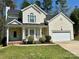 Charming home featuring a well-manicured lawn, cozy front porch, and an attached two-car garage at 10550 Worsley Ln, Charlotte, NC 28269