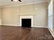 Living room with decorative fireplace, hardwood floors, crown molding, and multiple electrical outlets at 10550 Worsley Ln, Charlotte, NC 28269