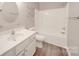 Well-lit bathroom featuring a single sink vanity, toilet and shower-tub combo at 115 Scotch Irish Ln, Troutman, NC 28166