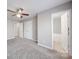 Spacious bedroom features a ceiling fan, neutral walls, carpet floors and ensuite bathroom at 115 Scotch Irish Ln, Troutman, NC 28166