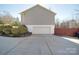 View of the side and back of the house with driveway leading to the garage under the house at 115 Scotch Irish Ln, Troutman, NC 28166
