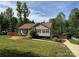 Inviting single-story home with a manicured lawn, landscaped garden, and a cozy front porch at 115 Scotch Irish Ln, Troutman, NC 28166