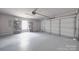Clean garage featuring a garage door, shelves, and a bright window at 115 Scotch Irish Ln, Troutman, NC 28166