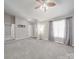 Spacious living room boasting neutral carpet, a fan, and a front door entrance at 115 Scotch Irish Ln, Troutman, NC 28166