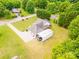Aerial view of property with large garage, car port, and circular driveway, surrounded by trees at 119 Era St, Troutman, NC 28166