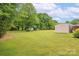 Expansive backyard with mature trees and a storage shed, offering ample space for outdoor activities at 119 Era St, Troutman, NC 28166