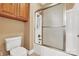 Bathroom featuring a toilet, tub and a shower with frosted glass doors and wood-colored storage cabinets at 119 Era St, Troutman, NC 28166
