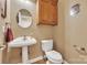 Cozy half bath featuring hardwood floors, a pedestal sink, and a toilet at 119 Era St, Troutman, NC 28166