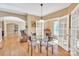 Cozy dining area with hardwood floors, glass table, and view into living room and den at 119 Era St, Troutman, NC 28166