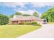 Brick home with a three-car garage and RV shelter, surrounded by lush greenery and mature trees at 119 Era St, Troutman, NC 28166