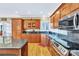 Traditional kitchen with wood cabinets, granite countertops, stainless steel appliances, and hardwood flooring at 119 Era St, Troutman, NC 28166