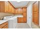 Laundry room with oak cabinetry, tile floors, a utility sink, and a new front-load washing machine at 119 Era St, Troutman, NC 28166