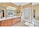 Bright primary bathroom featuring double vanity, spacious shower, and window over tub at 119 Era St, Troutman, NC 28166