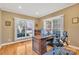 Bright home office with hardwood floors, a classic wooden desk, and a view of the outdoors through large windows at 119 Era St, Troutman, NC 28166