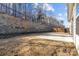 Spacious backyard with a retaining wall, a small patio, and newly installed wooden fence at 127 Tradesmen Trl, Troutman, NC 28166