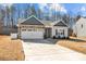 Beautiful home with a spacious driveway and attached two-car garage, perfect for a growing Gathering at 127 Tradesmen Trl, Troutman, NC 28166