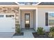 Close up of front entrance featuring a black front door, stone accents, and a manicured lawn at 127 Tradesmen Trl, Troutman, NC 28166