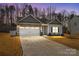 Charming home featuring a stone and vinyl exterior, two-car garage, and well-manicured lawn at 127 Tradesmen Trl, Troutman, NC 28166