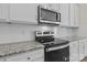 Close up view of stainless steel appliances and granite countertops; the kitchen has a white subway tile backsplash at 127 Tradesmen Trl, Troutman, NC 28166
