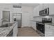 Well-lit kitchen features stainless steel appliances, granite counters, white subway tile backsplash, and ample cabinet space at 127 Tradesmen Trl, Troutman, NC 28166