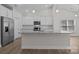 Bright kitchen with stainless steel appliances, granite countertops and white cabinets at 127 Tradesmen Trl, Troutman, NC 28166