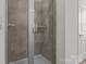 Modern shower with gray tiled walls, glass door, and updated fixtures at 127 Tradesmen Trl, Troutman, NC 28166