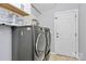 Laundry room featuring modern machines, storage shelf and white door at 14125 Derby Farm Ln, Charlotte, NC 28278