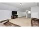 This is a cozy bonus room with a leather sofa, a television, and neutral carpet at 14125 Derby Farm Ln, Charlotte, NC 28278