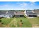 Aerial view of the backyard showing the patio, green lawn, and surrounding houses in the neighborhood at 1615 Shoals Ave # 158, Belmont, NC 28012