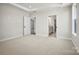 Spacious bedroom with neutral carpet and walls, featuring a doorway to the bathroom and other rooms at 1615 Shoals Ave # 158, Belmont, NC 28012