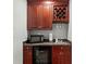 Elegant bar area featuring rich wood cabinetry, a wine rack, and a built-in sink at 1742 Verdict Ridge Dr, Denver, NC 28037