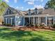 A charming blue home featuring a welcoming front porch with classic columns and manicured landscaping at 1742 Verdict Ridge Dr, Denver, NC 28037