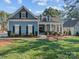 Charming blue home featuring a welcoming front porch with classic columns and manicured landscaping at 1742 Verdict Ridge Dr, Denver, NC 28037