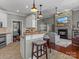 Open kitchen with granite countertops, bar seating, and seamless flow into the living area with stone fireplace at 1742 Verdict Ridge Dr, Denver, NC 28037