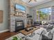 Cozy living room with a stone fireplace, mounted TV, and comfortable seating area bathed in natural light at 1742 Verdict Ridge Dr, Denver, NC 28037