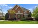Stately brick home featuring a manicured lawn and lush landscaping at 1754 Sterling Rd, Charlotte, NC 28209