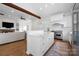 Open-concept kitchen with white cabinetry, stainless steel appliances, an island, and hardwood flooring at 1754 Sterling Rd, Charlotte, NC 28209