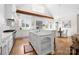 Bright, open kitchen features a large island, modern appliances, white cabinetry, and a vaulted ceiling with exposed beam at 1754 Sterling Rd, Charlotte, NC 28209