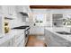 Bright white kitchen showcasing stainless steel appliances, a large island with a sink, and hardwood flooring at 1754 Sterling Rd, Charlotte, NC 28209