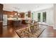 A kitchen with wood floors, dining table and chairs, dark wood cabinets, and stainless steel appliances at 2108 Clarion Dr, Fort Mill, SC 29707