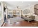 A living room space with a fireplace, sectional sofa, large artwork, wood floors, and staircase to upper level at 2108 Clarion Dr, Fort Mill, SC 29707