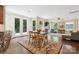 A living and dining space with hardwood floors, a fireplace, windows, and french doors with wooded view at 2108 Clarion Dr, Fort Mill, SC 29707