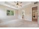Spacious main bedroom featuring a tray ceiling, fan, and access to the main bath at 2108 Clarion Dr, Fort Mill, SC 29707