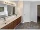 Bathroom featuring double sinks, a large mirror, and ample cabinet space with tile flooring and a view out the window at 215 Madelia Pl, Mooresville, NC 28115
