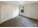 This bedroom features neutral walls, carpet, and a window for lots of natural light at 215 Madelia Pl, Mooresville, NC 28115