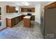 Well-lit kitchen featuring wooden cabinets, an island, stainless steel appliances and neutral countertops at 215 Madelia Pl, Mooresville, NC 28115