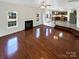 Bright living room with hardwood floors and a fireplace, seamlessly connecting to the kitchen through an open-concept design at 215 Madelia Pl, Mooresville, NC 28115