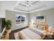 Serene main bedroom featuring a tray ceiling, a large window with sunlit view, and soft, neutral decor at 215 Madelia Pl, Mooresville, NC 28115